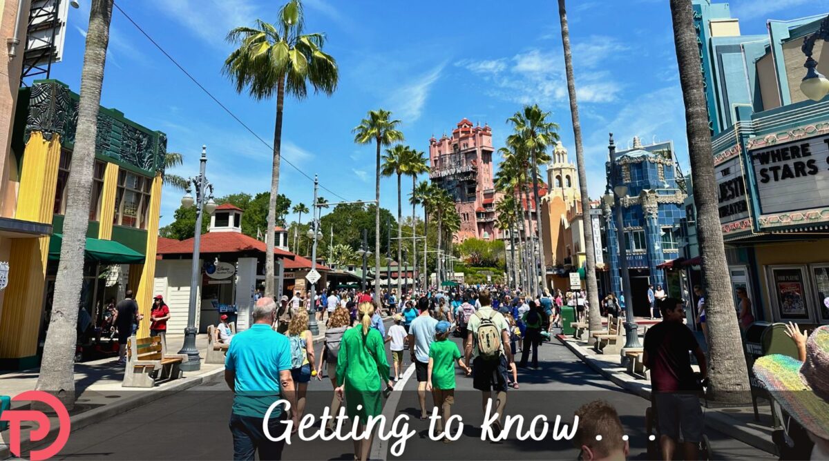 A long shot of Sunset Boulevard showing the Art Deco buildings on either side of park guests walking down the street